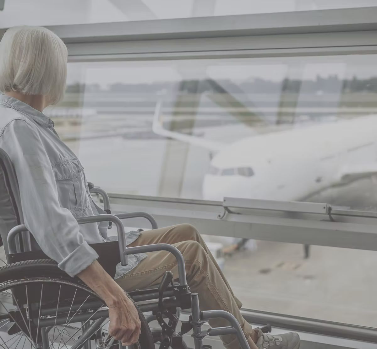 Passagère en fauteuil roulant devant l'avion